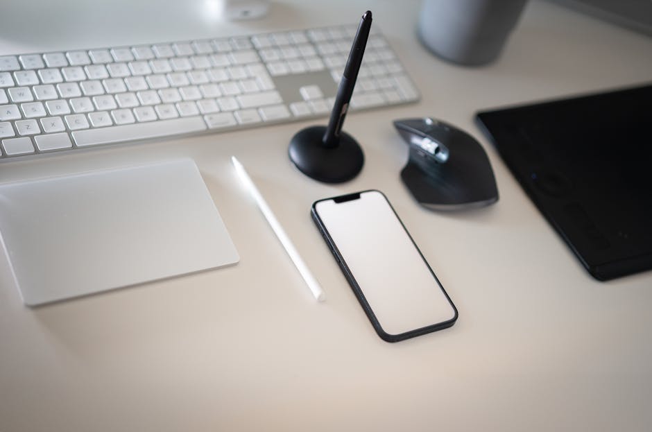 Clean and modern workspace featuring keyboard, smartphone, and wireless mouse.