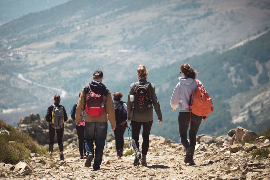 A group of people hiking along a rocky mountain trail, enjoying nature and adventure