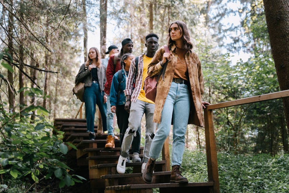 A diverse group of friends hiking down wooden steps in a lush forest setting